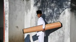 Warga menghadiri kegiatan zikir dan doa memperingati 20 tahun bencana gempa dan tsunami Aceh di salah satu kuburan massal pada Kamis pagi 26 Desember 2024. (CHAIDEER MAHYUDDIN/AFP)