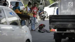 Pejalan kaki memberikan uang kepada seekor monyet yang menghibur pengguna jalan di kawasan Abdul Rachman Saleh, Jakarta, Sabtu (31/3). Bagi para penentangnya, pertunjukan topeng monyet dianggap melanggar etika terhadap hewan. (Liputan6.com/Faizal Fanani)
