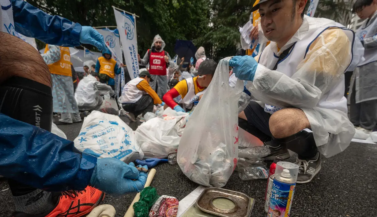 Para peserta menyortir sampah yang mereka pungut saat mengambil bagian dalam tahap Jepang "SpoGOMI World Cup 2023" di mana para tim memungut sampah sebanyak mungkin, di daerah Shinjuku, Tokyo pada tanggal 9 Oktober 2023. (Richard A. Brooks/AFP)