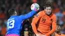Kiper Gibraltar Bradley Banda (kiri) meninju bola melewati penyerang Belanda Wout Weghorst pada laga Kualifikasi Piala Dunia 2022 zona Eropa Grup G di De Kuip, Rotterdam, Selasa (12/10/2021) dini hari WIB. Menjamu Gibraltar, Belanda menang 6 gol tanpa balas. (JOHN THYS/AFP)