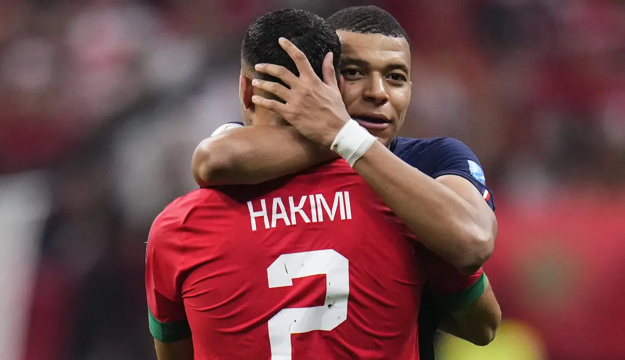 Penyerang #10 Prancis Kylian Mbappe memeluk bek Maroko #02 Achraf Hakimi pada akhir babak semifinal Piala Dunia 2022 di Al Bayt Stadium, Kamis (15/12/2022) dini hari WIB. Posisi bermain mereka membuat Mbappe dan Hakimi harus head to head di Al Bayt Stadium. (AP Photo/Manu Fernandez)