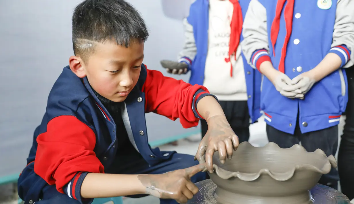 Sejumlah siswa sekolah dasar mencoba membuat porselen di bengkel kerja porselen Ru di Baofeng, Provinsi Henan, China, 15 November 2020. Baofeng dikenal sebagai produsen porselen Ru, satu dari lima porselen yang tersohor selama era Dinasti Song (960-1279) pada zaman China kuno. (Xinhua/He Wuchang)