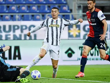 Striker Juventus, Cristiano Ronaldo, berusaha melewati kiper Cagliari, Alessio Cragno, pada laga Liga Italia di Sardegna Arena, Minggu (14/3/2021). Juventus menang dengan skor 3-1. (AFP/Albert0 Pizzoli)