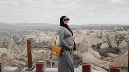 Gaya OOTD Aurel Hermansyah saat tengah liburan di Cappadocia ini tak lepas dari perhatian netizen. Tampil dengan dress abu-abu kala waktu hamil Ameena, pesona cantik Aurel kian terpancar. Mengenakan kacamata hitam, membuat wanita 24 tahun itu terlihat begitu menawan.(Liputan6.com/IG/@aurelie.hermansyah)