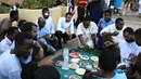Sejumlah pria Sudan menikmati makanan buka puasa selama bulan suci Ramadan di depan kedubes Inggris di ibukota Khartoum (23/5/2019). Duta Besar Inggris untuk Sudan, Irfan Sidiq menggelar buka puasa bersama di ibu kota tersebut. (AFP Photo/Ebrahim Hamid)