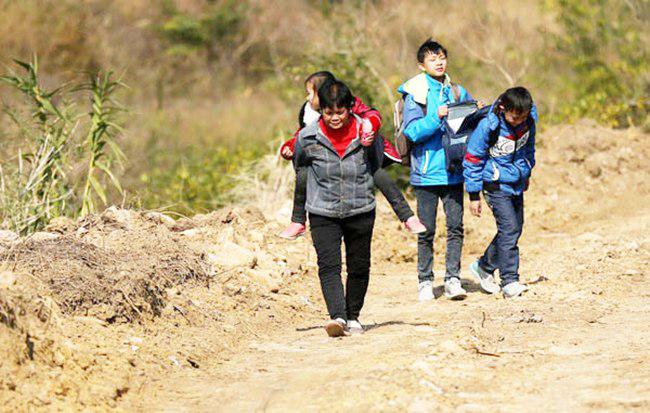 Nenek Huang harus menggendong cucunya yang paling kecil untuk berobat | foto: copyright chinadaily.com.cn