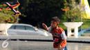 Seorang anak berusaha menerbangkan pesawat mainan saat bermain di Lapangan Monumen Tugu Pancasila TMII, Jakarta, Jumat (8/7). TMII masih menjadi lokasi favorit warga menghabiskan libur hari raya. (Liputan6.com/Helmi Fithriansyah)