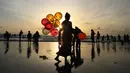 Seorang wanita menjual balon di Pantai Juhu, Mumbai, India, Selasa (24/8/2021). India mencatat penambahan 14.419 kasus positif COVID-19 pada 24 Agustus 2021. (AP Photo/Rafiq Maqbool)