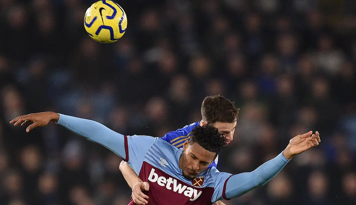 Striker West Ham United, Sebastien Haller (kiri) berebut bola dengan bek Leicester City, Jonny Evans pada pekan 24 Liga Inggris 2019-2020 di Stadion King Power, Rabu (22/1/2020). Menjamu West Ham , Leicester City berhasil menang meyakinkan dengan skor akhir 4-1. (Oli SCARFF / AFP)