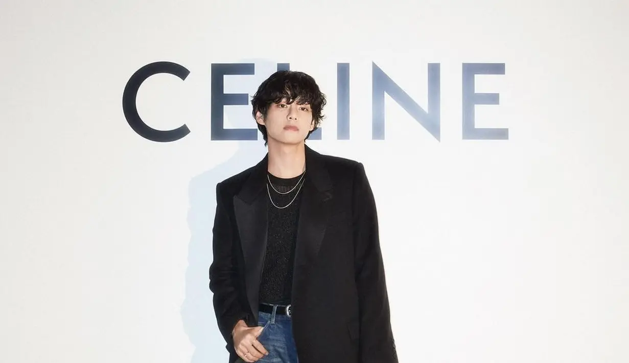 Taehyung di acara Celine, tampil ganteng luar biasa dengan outfit berwarna hitam. Ia mengenakan innerwear semi transparan, ditumpuk dengan long coat hitam, celana jeans, dan membawa tas yang juga berwarna hitam. Aksesori berupa kalung pun semakin mempermanis penampilannya, tanpa kesan berlebihan. Foto: Instagram.
