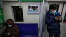 Para komuter mengenakan masker saat menaiki kereta bawah tanah di Beijing, China, Senin (17/2/2020). Wabah virus corona atau COVID-19 membuat warga Beijing beraktivitas menggunakan masker pelindung untuk mencegah terinfeksi virus yang telah menewaskan 1.770 orang tersebut. (AP Photo/Andy Wong)