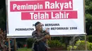 Warga duduk di depan spanduk yang berisi dukungan terhadap Jokowi, di sekitar Tugu Proklamasi, Jakarta, Kamis (21/5/2015). Spanduk tersebut dipasang dalam rangka memperingati 17 tahun reformasi. (Liputan6.com/Faizal Fanani)