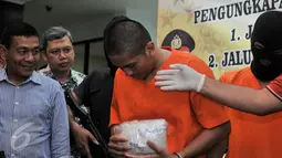 Salah satu tersangka diperlihatkan petugas saat Press Release di kantor Bareskrim Cawang, Jakarta, Selasa (7/3). Bareskrim berhasil mengungkap kasus peredaran narkotika jaringan internasional Malaysia-Indonesia. (Liputan6.com/Yoppy Renato)