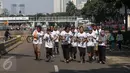 Sejumlah anak muda mengenakan kaos bertuliskan kawan8 berlari saat Car Free Day di kawasan Senayan, Jakarta, Minggu (24/7). Kegiatan ini dilaksanakan dalam rangka memperingati hari keadilan internasional. (Liputan6.com/Fery Pradolo)