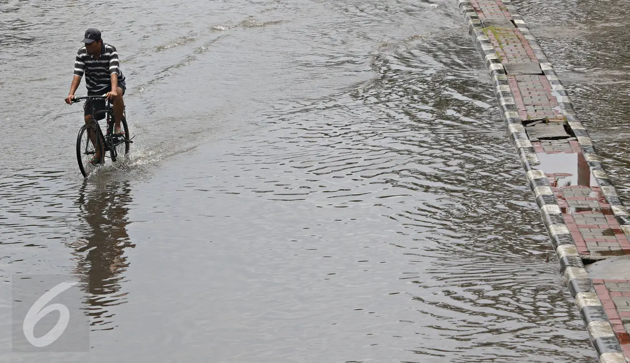 Warga berusaha menerobos banjir yang merendam Jalan Panjang, Jakarta Barat, Jumat (26/2). Hujan yang mengguyur wilayah Jakarta membuat sejumlah titik terendam banjir dengan ketinggian sekitar 20 cm hingga 1 meter. (Liputan6.com/ Immanuel Antonius)