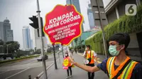 Relawan yang tergabung dalam Gerakan Mahasiswa Cegah Covid-19 membawa poster 'Ayo Lawan Corona' saat kampanye di Pelican Cross kawasan Thamrin, Jakarta, Senin (23/3/2020). (Liputan6.com/Faizal Fanani)