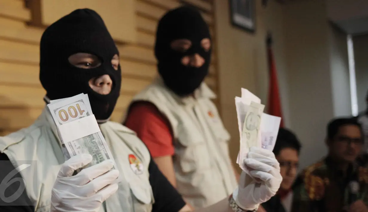  Penyidik KPK menunjukkan barang bukti uang OTT Bupati Klaten di Gedung KPK, Jakarta, Sabtu (31/12). Barang bukti uang sejumlah 2 milyar digunakan untuk suap pengaturan jabatan di lingkungan Pemerintah Kabupaten Klaten. (Liputan6.com/Helmi Afandi)