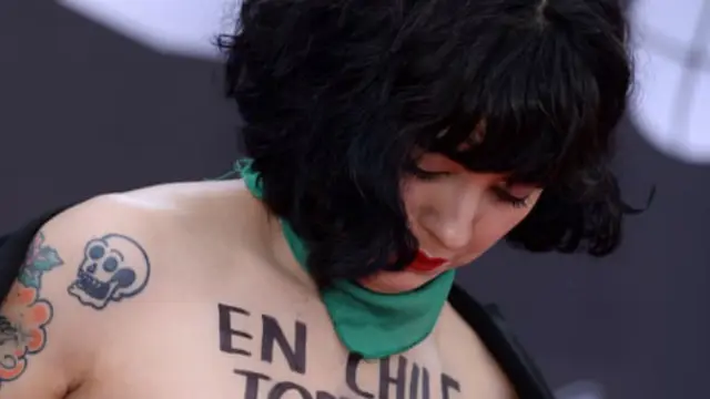 Penyanyi Chile Mon Laferte memperlihatkan payudaranya selama siaran anugerah musik Grammy Latin. Aksinya itu ditujukan untuk mendukung demonstran anti-pemerintah di negara asalnya. (Bridget Bennett / AFP PHOTO)