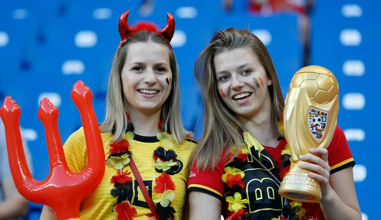 Dua suporter Belgia berpose sebelum pertandingan antara Belgia melawan Jepang pada 16 besar Piala Dunia 2018 di Rostov Arena, Rusia (2/7). Belgia berhasil mengalahkan Jepang 3-2 dan melaju ke babak 8 Besar. (AP Photo/Rebecca Blackwell)
