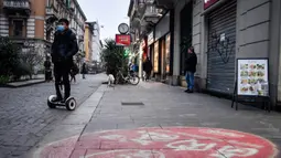 Aktivitas warga di sebuah jalan di pusat Kota Milan, Italia, Selasa (25/2/2020). Pemerintah Italia telah mengunci 11 kota terkait virus corona atau COVID-19 di negaranya. (Claudio Furlan/LaPresse via AP)