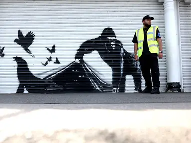 Sebuah karya seni oleh seniman jalanan Banksy, yang kesembilan yang dirilis dalam sembilan hari, menggambarkan seekor gorila yang sedang melepaskan hewan, di bagian depan rana di luar kebun binatang London, pada 13 Agustus 2024. (Adrian DENNIS / AFP)