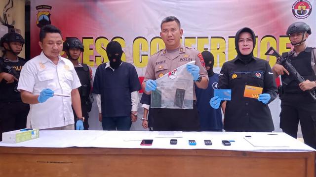 Tersangka pelaku penipuan dan penyebar konten asusila dijerat Pasal 378 KUHP tentang Penipuan dan Pasal 45 ayat (1) jo Pasal 27 ayat (1) UU Nomor 11 Tahun 2016 Tentang ITE, ancaman hukuman 4 tahun dan 6 tahun penjara. (Galoeh Widura/Liputan6.com)