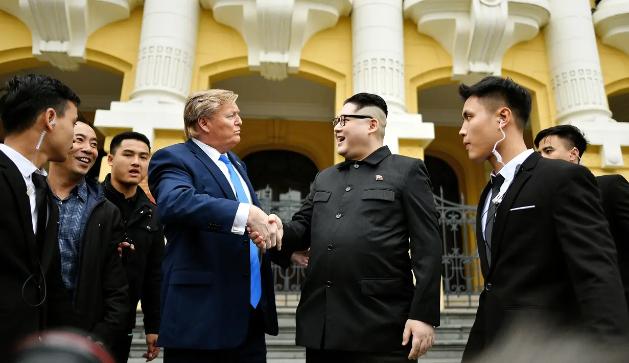 Peniru pemimpin Korea Utara Kim Jong-un asal China, Howard X dan peniru Presiden AS Donald Trump asal Australia, Dennis Alan bersalaman di luar Gedung Opera di Hanoi, Vietnam (22/2). (AFP Photo/Manan Vatsyayana)