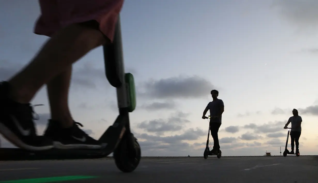 Pengendara menaiki skuter listrik  di sepanjang Venice Beach, Los Angeles, 13 Agustus 2018. Di kota-kota besar di Amerika Serikat, kendaraan listrik telah banyak bermunculan dari berbagai startup. (Mario Tama/Getty Images/AFP)