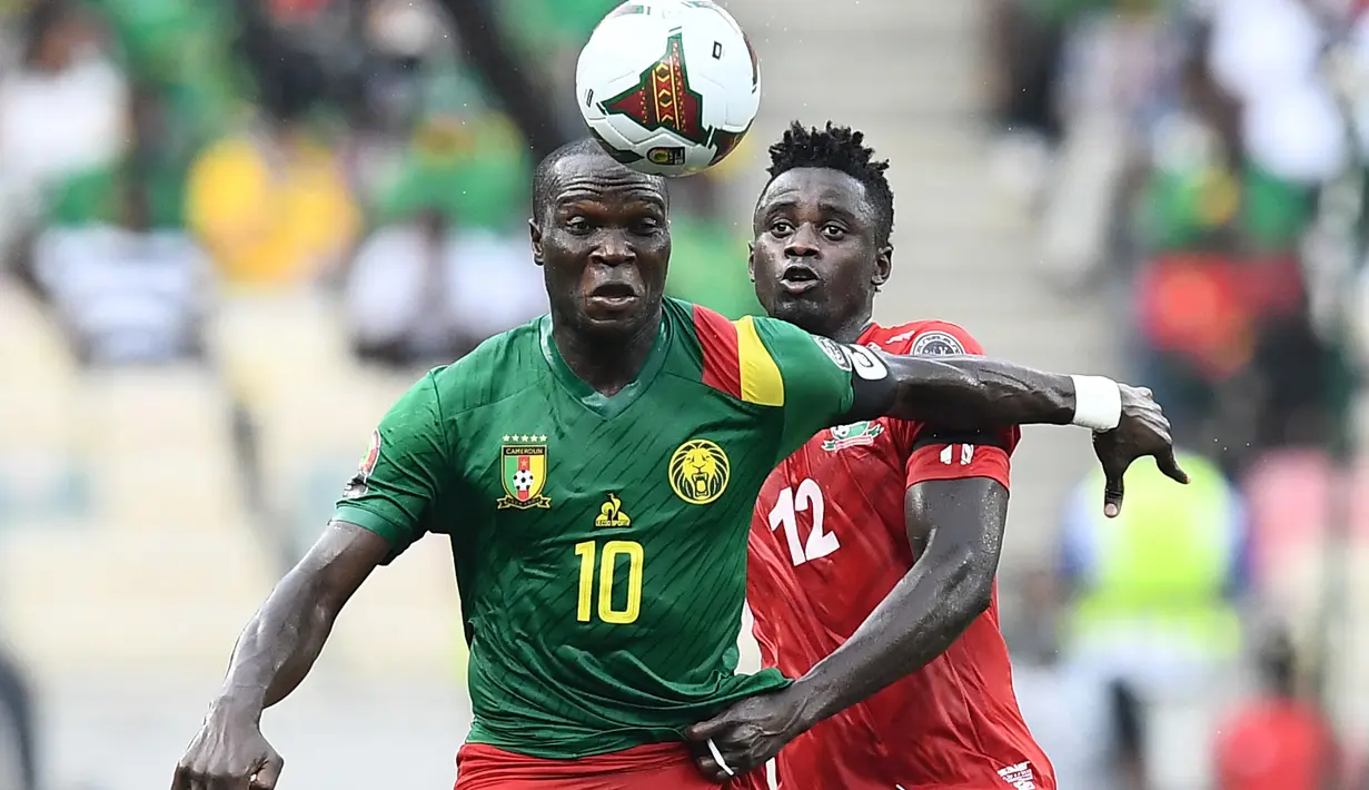 Pemain depan Kamerun Vincent Aboubakar (kiri) ditantang oleh bek Gambia James Gomez pada pertandingan perempatfinal Piala Afrika 2021 di Japoma Stadium, Minggu (30/1/2022) dini hari WIB. Kamerun melangkah ke semifinal usai menang atas Gambia, 2-0. (CHARLY TRIBALLEAU / AFP)