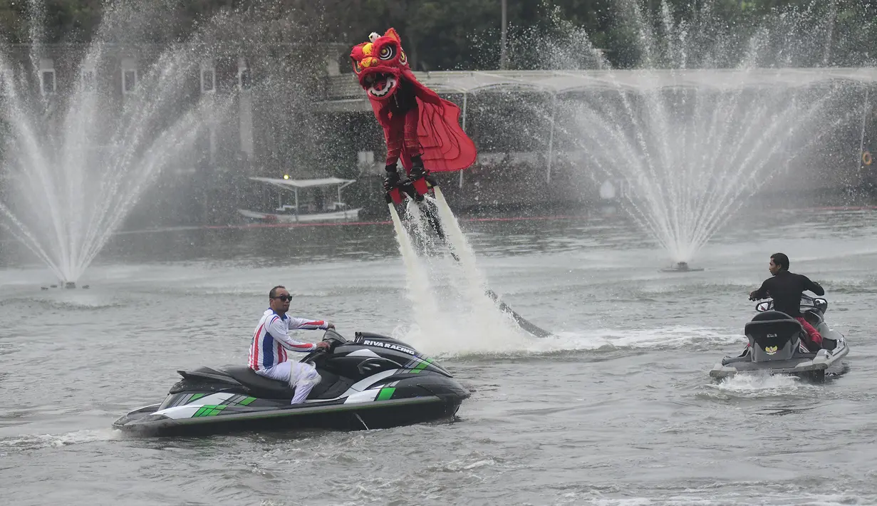Pengunjung juga berkesempatan untuk memberikan angpao langsung kepada penampil barongsai saat atraksi berlangsung. Tampak dalam foto, penampil mengenakan kostum barongsai beratraksi Aerial Lion Dance di Danau Senayan Park, Jakarta, 14 Februari 2026. (merdeka.com/Arie Basuki)