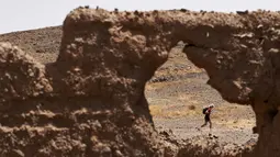 Seorang peserta berlari saat mengikuti kejuaraan marathon des Sables di gurun Sahara, Maroko, (10/4). Peserta akan menempuh jarak sekitar 257 kilometer melintasi panasnya gurun Sahara. (AFP PHOTO/JEAN-PHILIPPE Ksiazek)