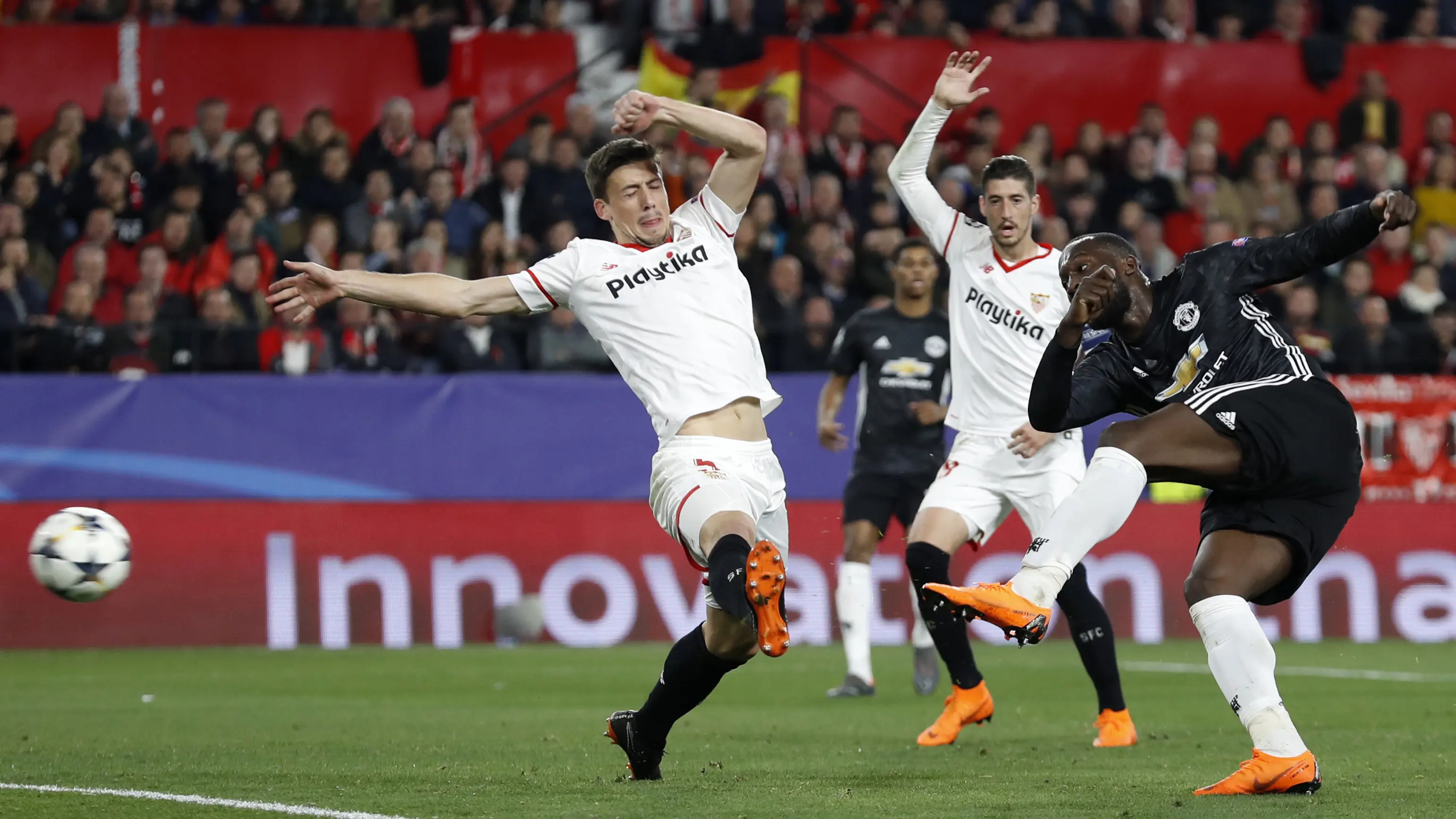 Romelu Lukaku (kanan) melepaskan tembakan melewati adangan dua pemain Sevilla pada laga 16 besar Liga Champions di Ramon Sanchez Pizjuan stadium, Seville, (21/2/2018) (AP/Miguel Morenatti)