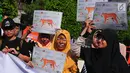 Peserta aksi dari forum harimaukita membentangkan spanduk dan poster saat mengkampanyekan Global Tiger Day di Bundaran HI, Jakarta, Minggu (30/7). (Liputan6.com/Helmi Afandi)