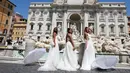 Para perempuan yang upacara pernnikahannya ditunda atau dibatalkan akibat pandemi covid-19 melakukan protes di Trevi Fountain, Roma, Selasa (7/7/2020). Mereka memprotes kebijakan pemerintah Italia yang masih melarang adanya acara pernikahan, meski lockdown sudah dilonggarkan. (AP/Riccardo De Luca)