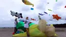 Wanita Indonesia menyiapkan layang-layang mereka untuk diterbangkan saat festival layang-layang di Bali, Indonesia, (4/8). Festival ini diselenggarakan untuk mempromosikan pariwisata di pulau resor. (AP Photo/Firdia Lisnawati)