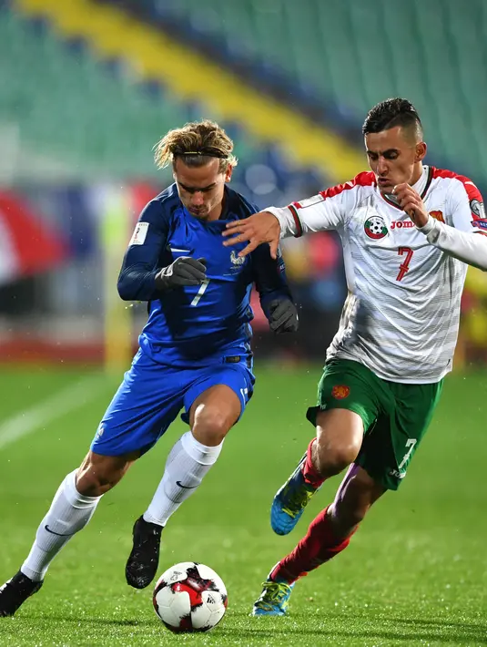 Pemain timnas Prancis, Antoine Griezmann berebut bola dengan pemain Bulgaria, Georgi Kostadinov pada laga Kualifikasi Piala Dunia 2018 zona Eropa Grup A, Sabtu (7/10). Les Bleus unggul 1-0 lewat gol lewat gol Blaise Matuidi. (Dimitar DILKOFF / AFP)