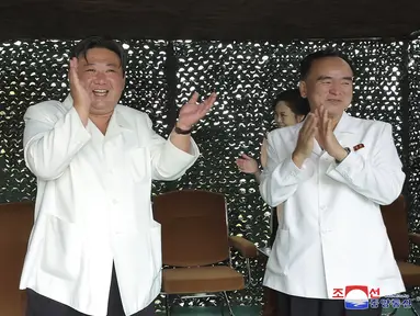 Pemimpin Korea Utara Kim Jong-un (kiri) bertepuk tangan saat menyaksikan uji tembak rudal balistik antarbenua baru (ICBM) "Hwasong-18" di lokasi yang dirahasiakan di Korea Utara, pada 12 Juli 2023.(Korean Central News Agency/Korea News Service via AP)
