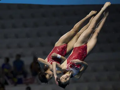 Aksi Zhang Jiaqie dan Zhang Minjie pasangan peloncat indah asal China yang meraih medali emas di nomor papan 10 meter sinkronisasi pada Asian Games 2018 di Stadion Akuatik, Gelora Bung Karno Senayan Jakarta, Selasa (28/8/2018). (Bola.com/Peksi Cahyo)
