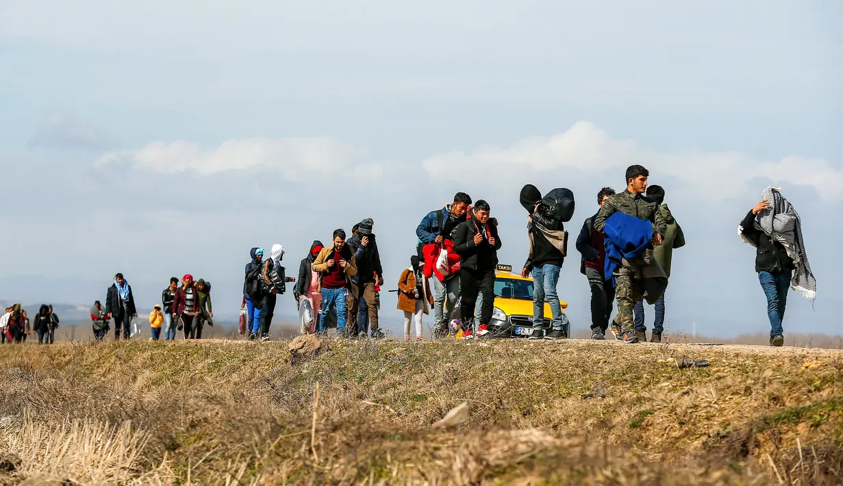 Para migran berjalan menuju gerbang perbatasan Turki dengan Yunani di Ipsala, Edirne, Turki, Selasa (3/3/2020). Ribuan migran dan pengungsi dari Turki dilaporkan berusaha untuk menemukan jalan melintasi perbatasan darat ke Yunani. (AP Photo/Emrah Gurel)