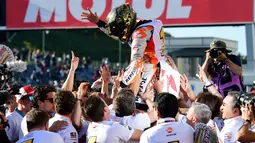 Pembalap Repsol Honda, Marc Marquez merayakan kemenangannya bersama tim setelah berhasil finish terdepan dalam MotoGP Jepang 2018 di Twin Ring Motegi, Minggu (21/10). Marquez menang dengan catatan waktu 42 menit 36,438 detik . (Martin BUREAU / AFP)