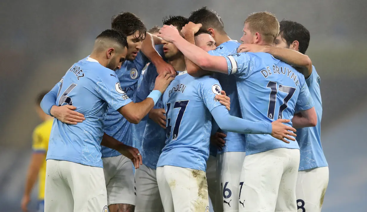 Para pemain Manchester City merayakan gol yang dibuat gelandang Phil Foden (tengah) ke gawang Brighton and Hove Albion dalam laga lanjutan Liga Inggris 2020/21 di Etihad Stadium, Rabu (13/1/2021). Manchester City menang 1-0 atas Brighton. (AFP/Clive Brunskill/Pool)