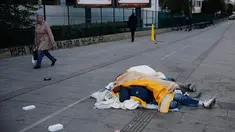 Pejalan kaki berjalan dekat para imigran yang tidur di jalanan Kota Paris, Prancis, Rabu (6/11/2019). Gelombang imigran membanjiri Prancis akibat konflik dan kemiskinan di Asia, Timur Tengah, dan Afrika sejak 2015. (AP Photo/Francois Mori)