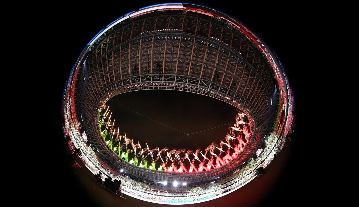 Gambar lensa fisheye menunjukkan kembang api yang menerangi langit pada awal upacara pembukaan Paralimpiade Tokyo 2020 di Olympic Stadium, Tokyo, Selasa (24/8/2021). Setelah ditunda selama setahun akibat pandemi Covid-19, Paralimpiade Tokyo 2020 akhirnya resmi dibuka. (Philip FONG/AFP)