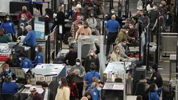 Penumpang antre di pos pemeriksaan di terminal Bandara Internasional Denver di Denver, AS, Senin (3/1/2022). Badai musim dingin ditambah pandemi membuat frustrasi pelancong yang penerbangan pulang dari liburannya dibatalkan atau ditunda beberapa hari di awal tahun baru. (AP Photo/David Zalubowski)