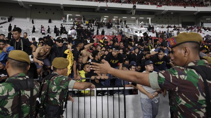 TNI mengevakuasi suporter Malaysia karena serangan dari suporter Timnas Indonesia saat laga Kualifikasi Piala Dunia 2022 di SUGBK, Jakarta, Kamis (5/9). (Bola.com/Vitalis Yogi Trisna)