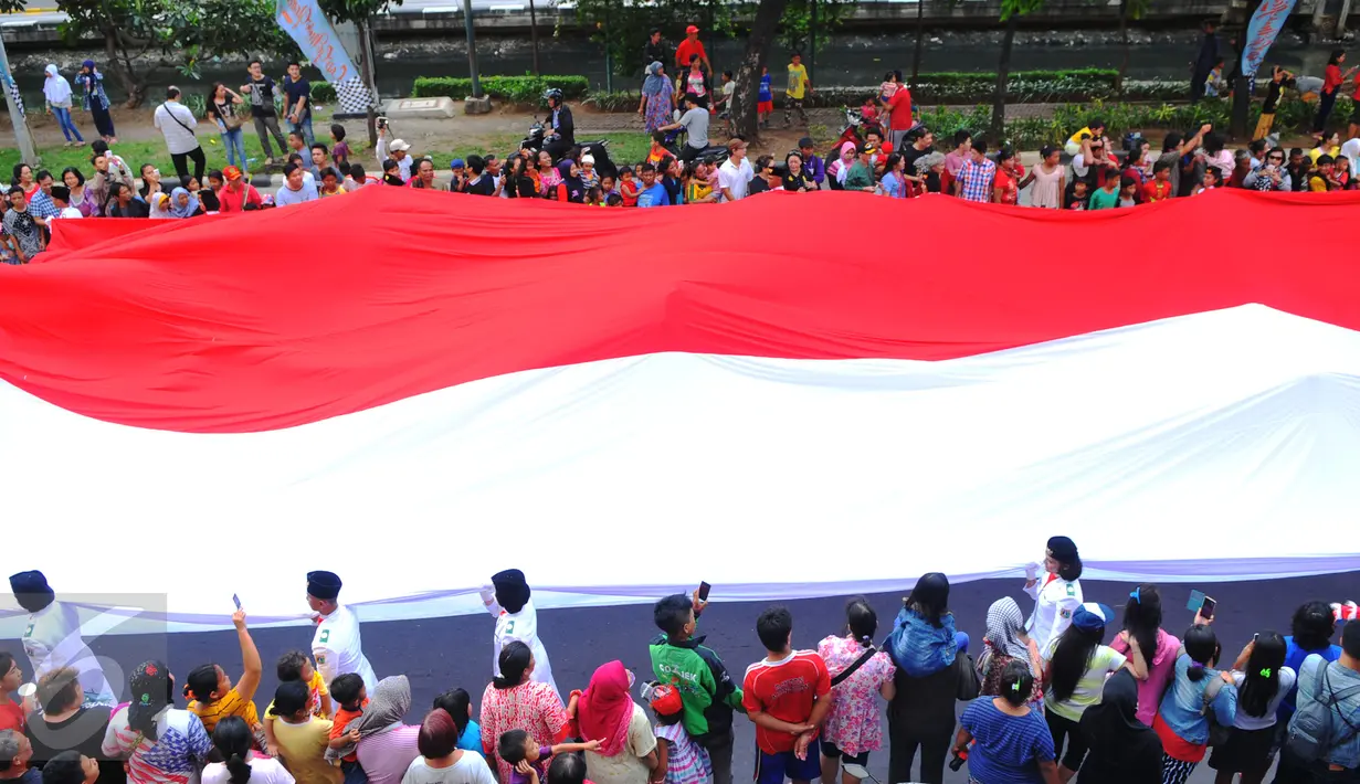Bendera merah putih berukuran besar diarak saat karnaval perayaan Cap Go Meh di Glodok, Jakarta, (21/2). Perayaan yang merupakan rangkaian terakhir perayaan Imlek itu diikuti 1477 peserta dengan menampilkan berbagai kesenian. (Liputan6.com/Faisal R Syam)