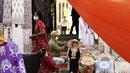 Seorang wanita mengenakan masker berjalan di Deira Souk di Teluk Emirat Dubai (30/9/2020). Barang yang dijual di Deira Souk juga paling diminati turis seperti rempah dan emas. (AFP/Karim Sahib)