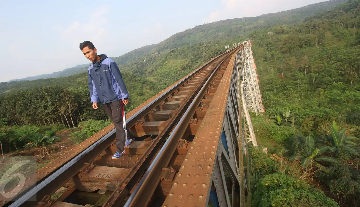 Seorang pria berjalan di Jembatan Cikubang, Cipatat, Kabupaten Bandung Barat, 5 Juli 2016. Jembatan Cikubang mulai digunakan sejak tahun 1906 dan masih kukuh berdiri dengan tinggi 80 meter dari dasar sungai Cikubang. (Liputan6.com/Immanuel Antonius)