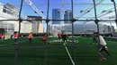 Sejumlah orang bermain bola di lapangan futsal di atap sebuah pusat perbelanjaan di Seoul, Korea Selatan (16/12). (AFP Photo/Jung Yeon-Je)