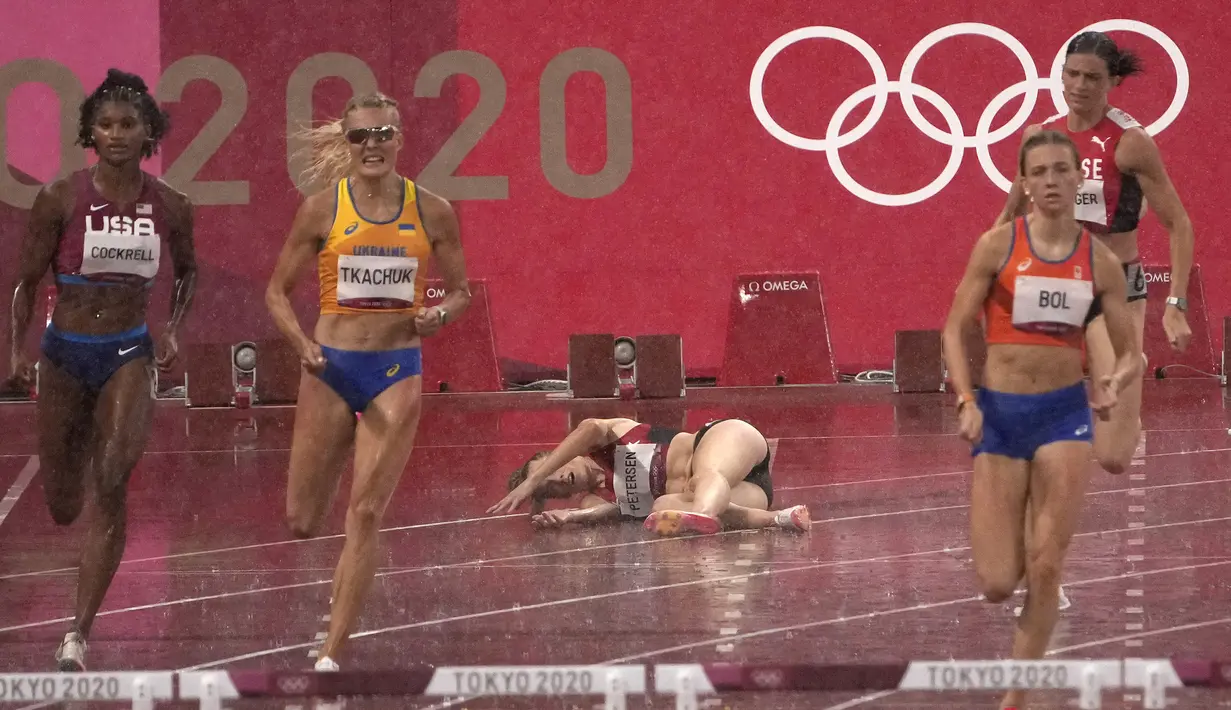 Sara Petersen dari Denmark (tengah) terjatuh saat Femke Bol (kanan) dari Belanda berlomba untuk memenangkan perlombaan lari gawang 400 meter putri Olimpiade Tokyo 2020 di Tokyo, Jepang, Senin (2/8/2021). (AP Photo/Charlie Riedel)